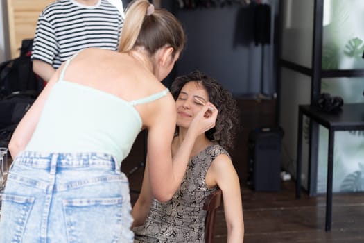 young beautiful woman doing makeup for woman