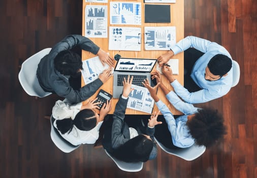 Top view multiracial analyst team use BI dashboard display on laptop screen, analyzing financial data for strategic decision. Fintech analyzes marketing indicators. Concord