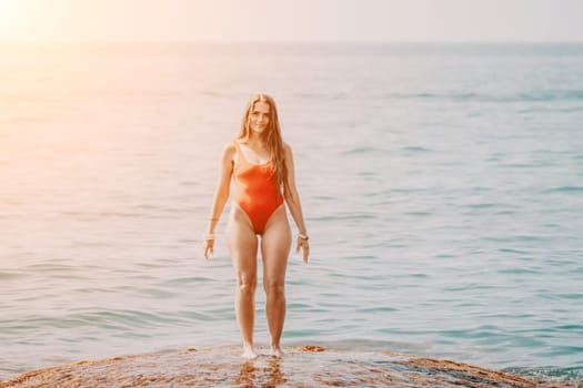 Woman sea yoga. Back view of free calm happy satisfied woman with long hair standing on top rock with yoga position against of sky by the sea. Healthy lifestyle outdoors in nature, fitness concept.