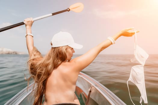 Woman in kayak back view. Happy young woman with long hair floating in transparent kayak on the crystal clear sea. Summer holiday vacation and cheerful female people having fun on the boat.