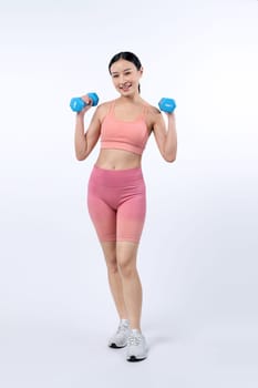 Vigorous energetic woman doing dumbbell weight lifting exercise on isolated background. Young athletic asian woman strength and endurance training session as body workout routine.