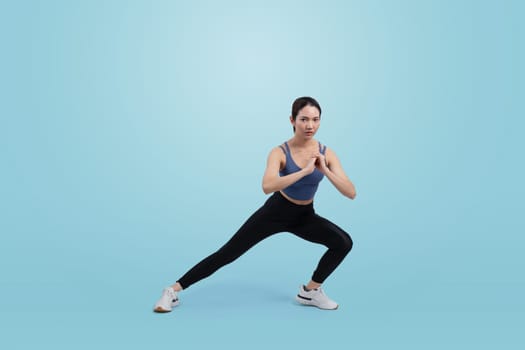 Young attractive asian woman in sportswear stretching before fitness exercise routine. Healthy body care workout with athletic woman warming up on studio shot isolated background. Vigorous