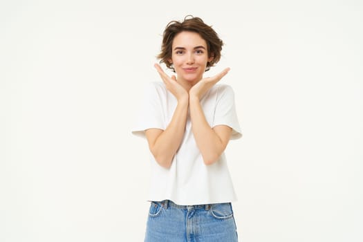 Portrait of cute brunette woman, looking with admiration and excitement, standing over white background.