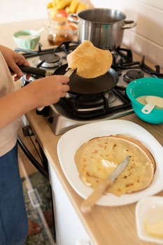a woman makes pancakes on a griddle.