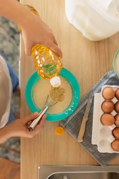 the hostess adds butter to the pancake batter.