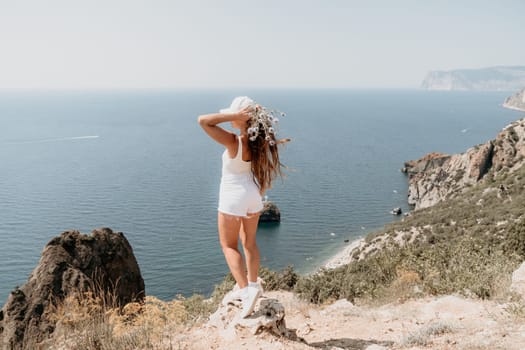 Woman travel sea. Young Happy woman in a long red dress posing on a beach near the sea on background of volcanic rocks, like in Iceland, sharing travel adventure journey