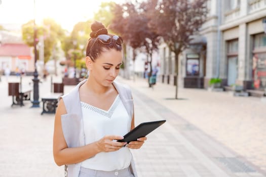 Beautiful woman smiling happy standing at city. Notepad in hand standing on street, in stylish clothes