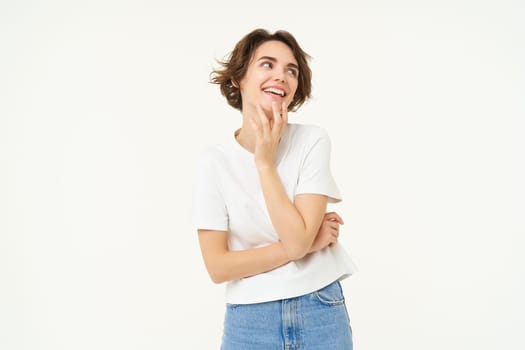 Portrait of carefree girl, gentle and feminine woman with short hair, laughing, posing over white studio background. Copy space