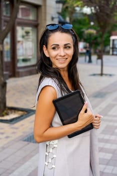 Successful businessman or entrepreneur smiling holding notepad while walking outdoor. City business woman working.