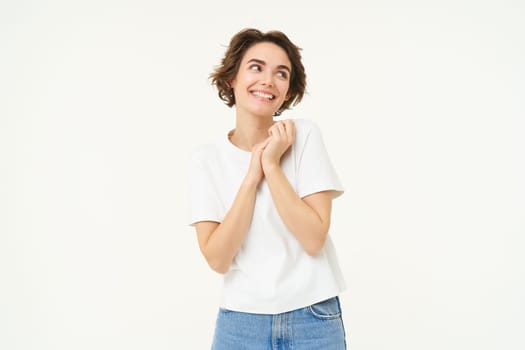 Portrait of cute, silly young woman, look with admiration, gazing at something, standing over white background.