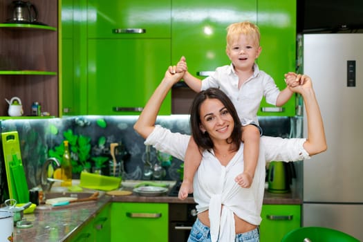 happy family, mother holding her son in her arms in the kitchen