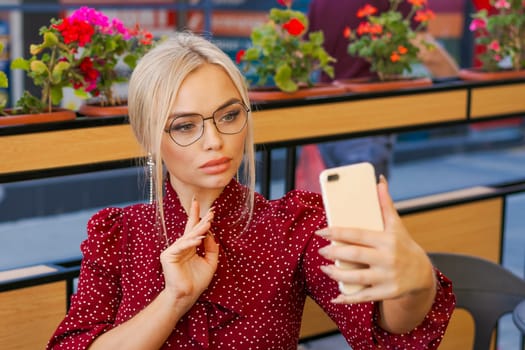 Beautiful woman sitting in a street cafe and talking on the phone