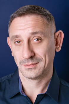 portrait of a man in a dark blue shirt