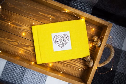 the yellow book lies on a wooden tray with the lights.