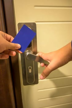 A hand inserting a blue card key into a modern hotel door lock, key electronic lock, hotel room, holidays in mallorca, spain,