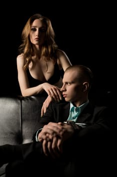 Gorgeous couple date shot on black leather sofa at night