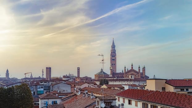 The charming city of cremona in italy at sunset, showcasing rooftops, the duomo, and the torrazzo bell tower, blending historic architecture with terracotta roofs in a picturesque scene
