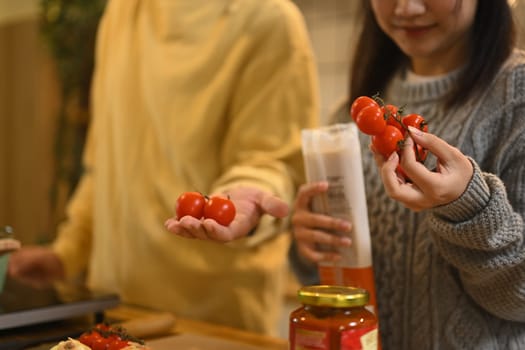 Young couple selecting fresh tomatoes for a delicious meal.