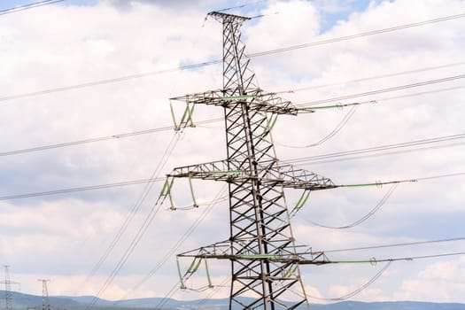 High voltage towers with sky background. Power line support with wires for electricity transmission. High voltage grid tower with wire cable at distribution station. Energy industry, energy saving.