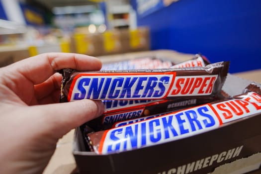 Tyumen, Russia-November 02, 2024: Snickers chocolate bar. Snickers bars are produced by Mars Incorporated.