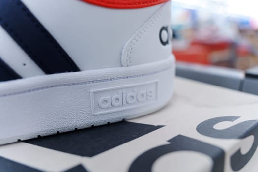 Tyumen, Russia-August 11, 2024: White athletic shoes adidas displayed on shelves in a retail store during the day