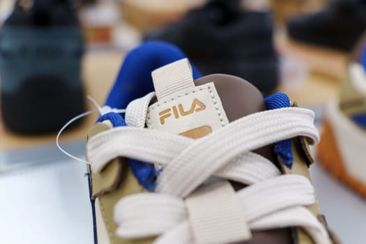 Tyumen, Russia-August 11, 2024: Fila sneaker is prominently displayed with detailed lacing and a visible brand tag, viewed inside a retail shop.