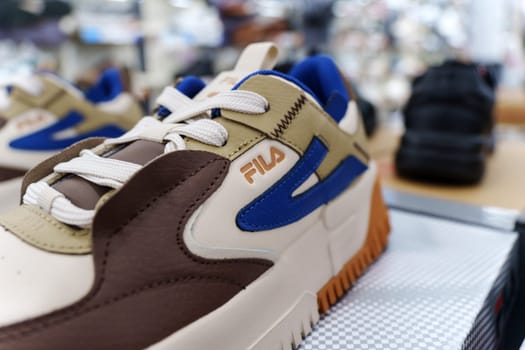 Tyumen, Russia-August 11, 2024: Fila sneaker is prominently displayed with detailed lacing and a visible brand tag, viewed inside a retail shop.