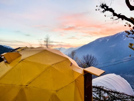 geodesic and swiss tents overlooking manali valley at sunset at a popular glamping spot near hampta village for eco freindly and comfortable adventure stays
