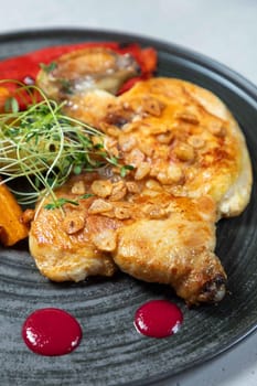 Enjoying a delicious roasted chicken breast with garlic, herbs, and sauce on a plate