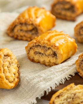 Freshly baked rugelach with poppy seeds filling lying on linen cloth