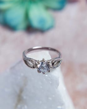 Silver ring with big diamond sparkling on white stone is perfect as a gift for valentine's day or wedding