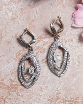 Elegant silver earrings with sparkling diamonds, showcasing their exquisite design and craftsmanship