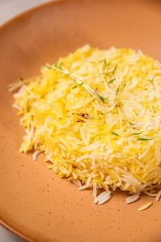 Saffron rice seasoned with saffron threads and sprigs of thyme on a plate
