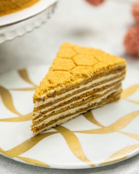 Slice of multi-layered honey cake resting on a decorative plate