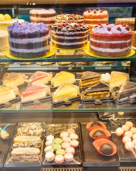 Delicious cakes and pastries are waiting for customers inside a bakery shop window