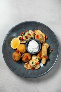 Plate of delicious fried appetizers is ready to be shared on a white table