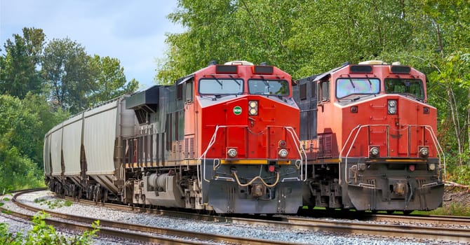 Two red locomotives are waiting for the semaphore signal to proceed with railway traffic in Burnaby, BC.