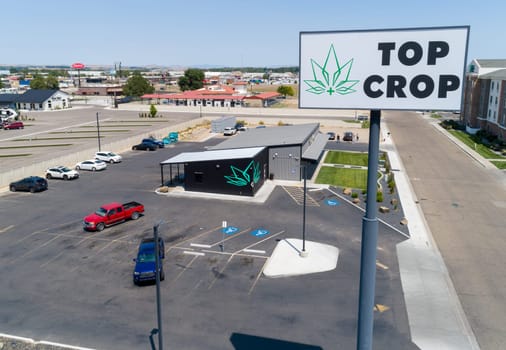 A sign for Top Crop is visible in the background. The image is of a parking lot with several cars parked in it