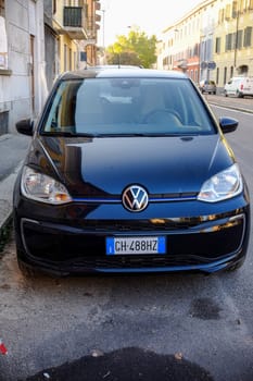 Cremona, Itally - October 6th 2024 Modern design and eco-friendly technology showcased in a parked black volkswagen up! electric car on a residential street, viewed from the front