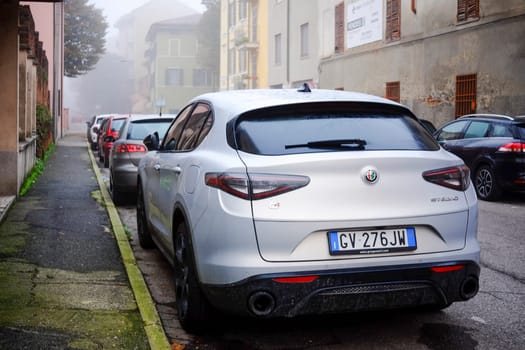 Cremona, Lombardy, Italy - November 7th 2024 Modern silver metallic suv parked on a misty city street in autumn
