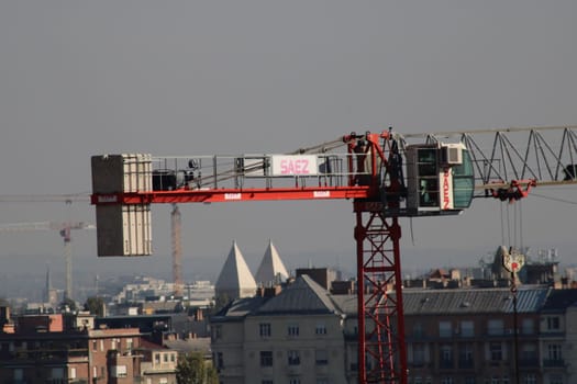 The construction crane stands prominently against the skyline, busy with construction work, showcasing the growth and development of the surrounding urban landscape.