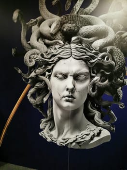 A striking depiction of Medusa features her snake hair and intense facial expression, prominently displayed in an art exhibition, highlighting the detailed craftsmanship.