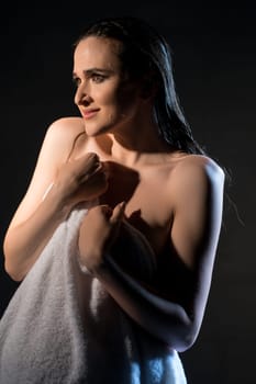 Gorgeous pregnant brunette wearing only a shirt portrait in a shower in the dark