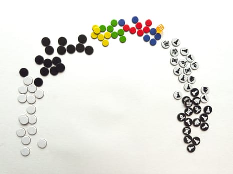 Colorful game pieces arranged in rainbow formation on white background.
