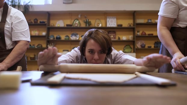 A determined and passionate baker diligently practices rolling dough in a lively and engaging cooking class environment. Stock Clip