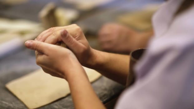 Talented artists shaping wet clay in a busy pottery workshop, showcasing their remarkable skill and creativity. Stock Clip