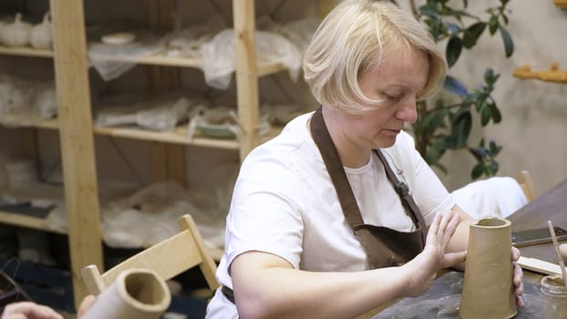 An artisan dedicates time and effort to expertly shape beautiful clay pottery in a creative workshop. Stock Clip