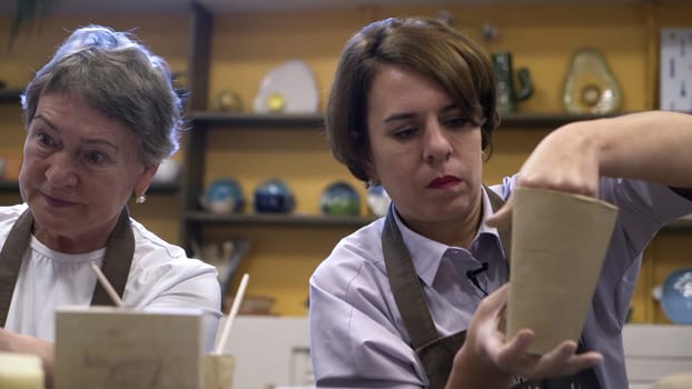 Two talented women are crafting pottery, showcasing their creativity and passion for artistic expression. Stock Clip