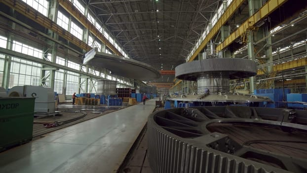 The interior of a large manufacturing facility shows heavy machinery and equipment for various production processes. Stock Clip
