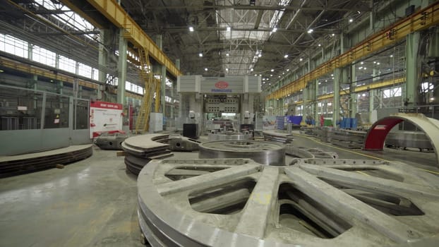 A spacious industrial facility featuring heavy machinery and materials for large-scale manufacturing. Stock Clip